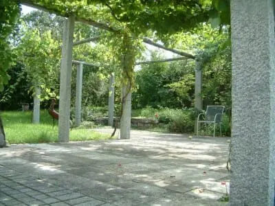 Pergola mit Naturstein-Pfeilern und Begrünung